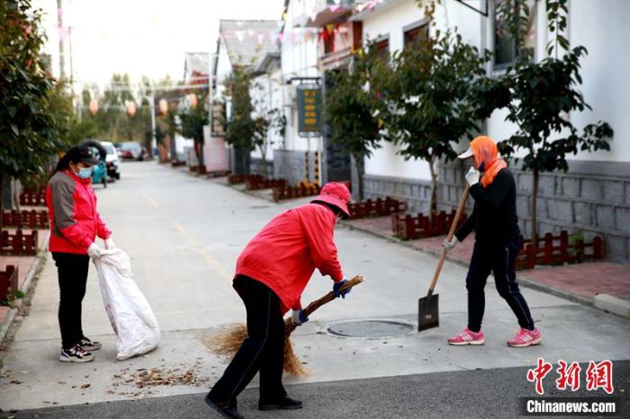 人们在清扫村中的道路。梁犇 摄