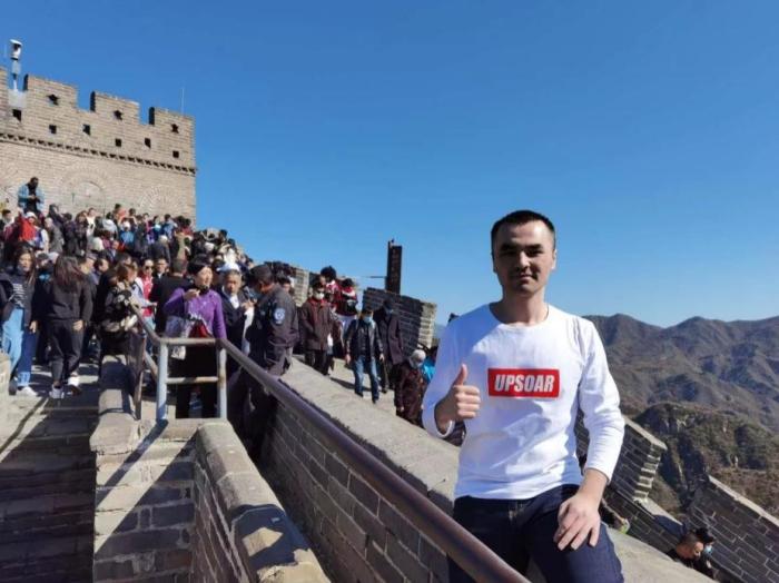 图为王力正在攀爬长城。