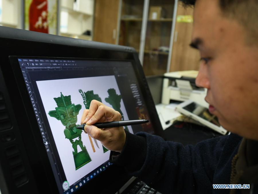 Zeng Zhou works on the design of a toy figure at a cultural industrial park in Chengdu, southwest China's Sichuan Province, Feb. 4, 2021. Zeng Zhou is a 31-year-old independent designer working on toy figure design. Inspired by a visiting experience at Sanxingdui Museum in Sichuan, Zeng decided to design model figures imitating bronze relics of the Sanxingdui Ruins, which are believed to be remnants of the Shu Kingdom dating back 2,600 years to 4,800 years, blending traditional Chinese culture with fashion toys. Zeng Zhou is now dedicated to optimizing his design and promoting mass production of his toy figures. 